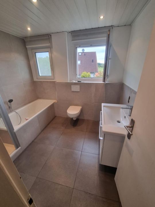 Familienbad mit Badewanne – Bodenfliesen in Taupe