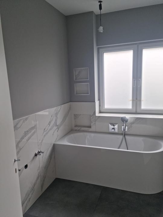 Badewanne vor Marmorwand – Marmoroptik & Wandnischen